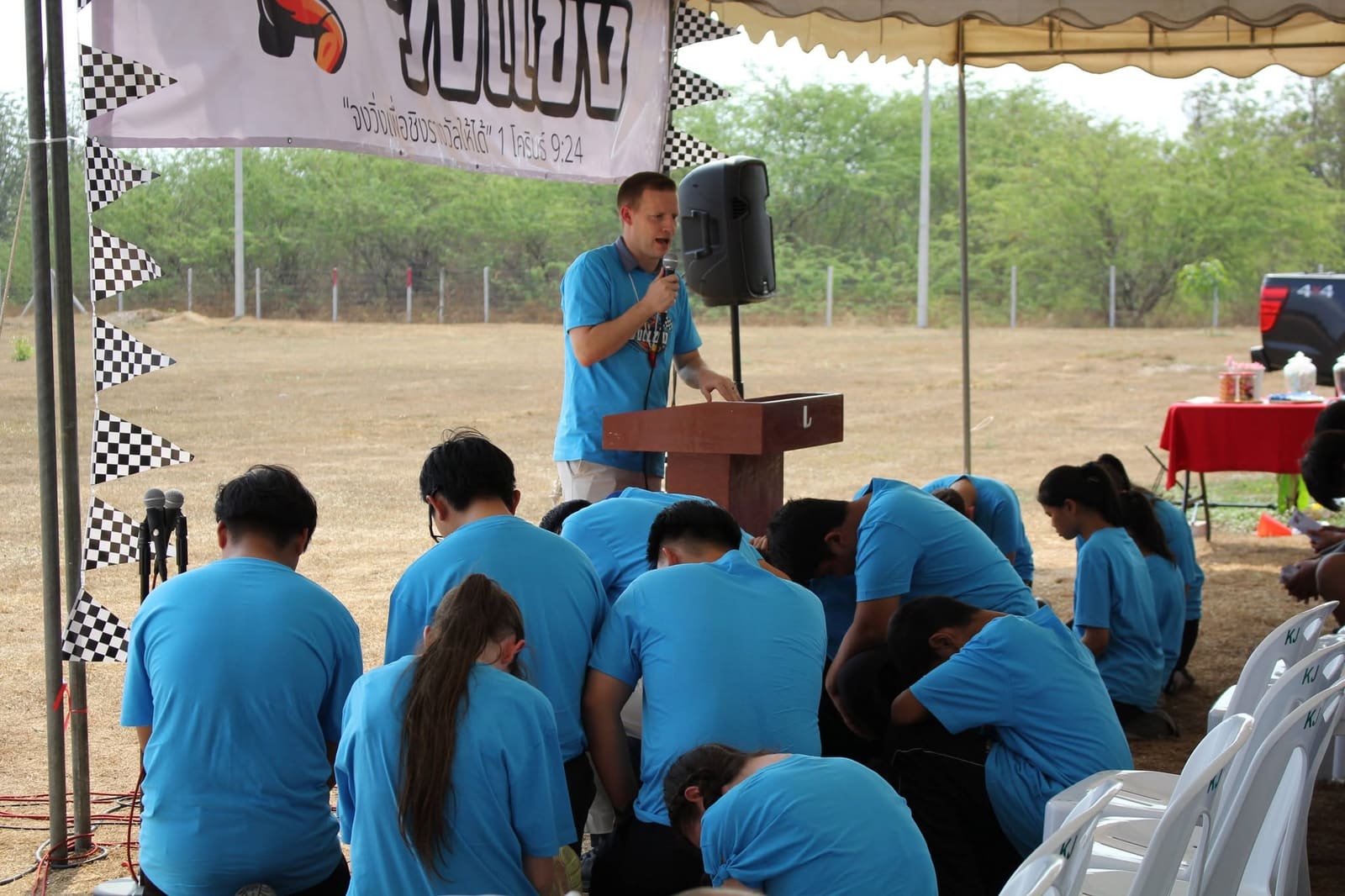 Young people in prayer at an outdoor gathering